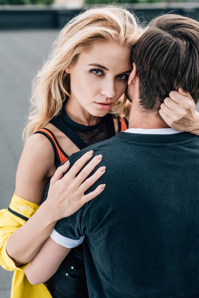 blonde and attractive woman hugging with man on roof  - Photo, Image