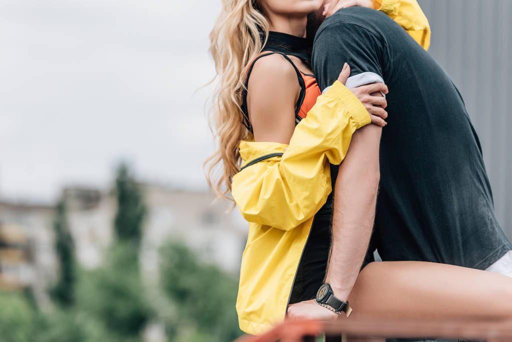vista ritagliata della donna in giacca gialla che abbraccia con l'uomo in t-shirt
  - Foto, immagini