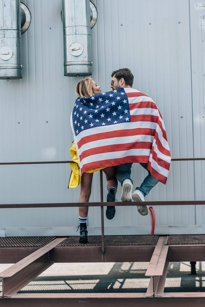 visão traseira de mulher e homem com bandeira americana no telhado
  - Foto, Imagem