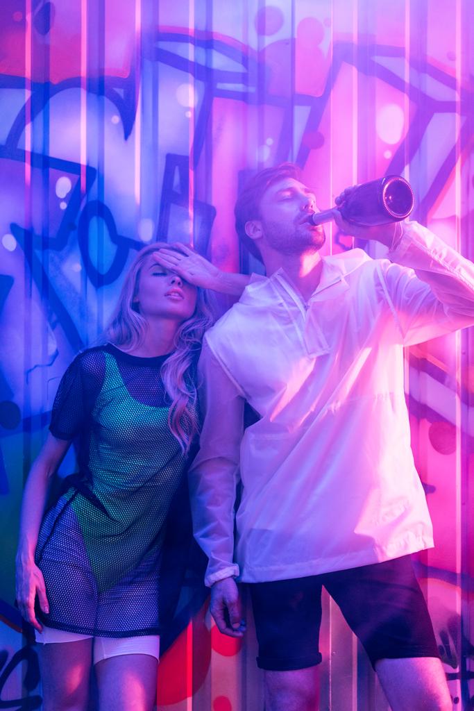aantrekkelijke en blonde vrouw met gesloten ogen en knappe man drinken champagne - Foto, afbeelding