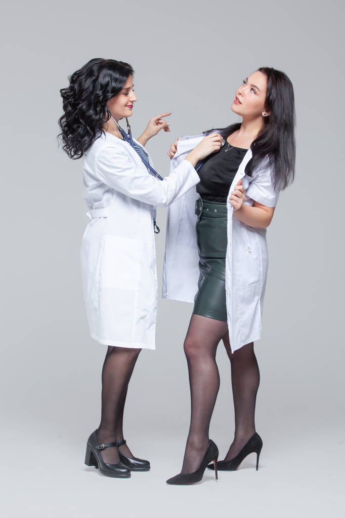 Γυναίκα γιατρός εξετάζει μια άλλη γυναίκα με στηθοσκόπιο - Φωτογραφία, εικόνα