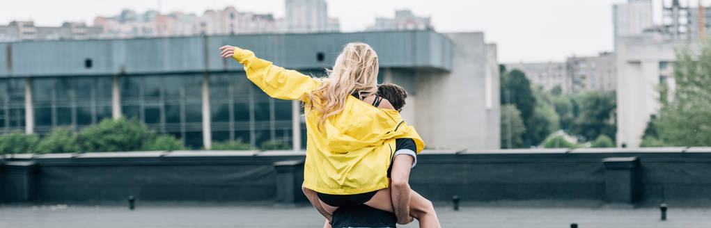 pohled na blonďatou ženu, jak si hraje s mužem na střeše  - Fotografie, Obrázek