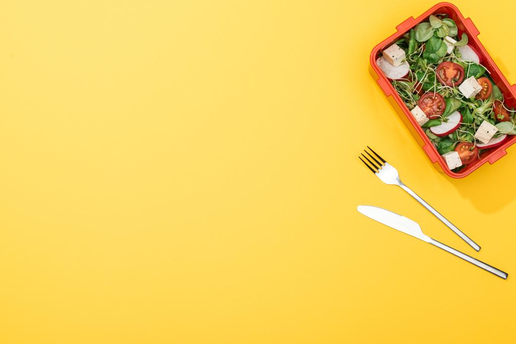 top view of lunch box with salad near fork and knife - Photo, Image