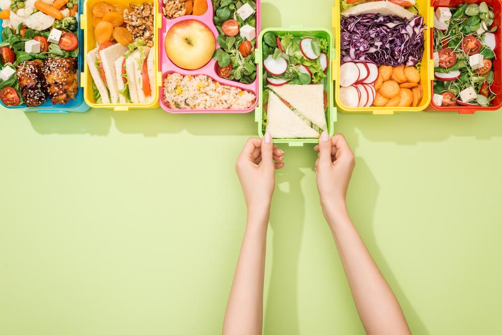 abgeschnittene Ansicht einer Frau bei der Auswahl von Lunchpaketen mit Lebensmitteln - Foto, Bild