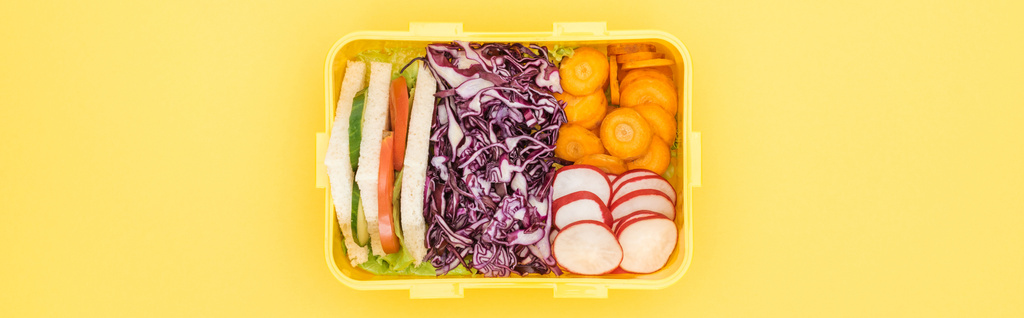 panoramatický záběr polední krabice s jídlem na žlutém pozadí - Fotografie, Obrázek