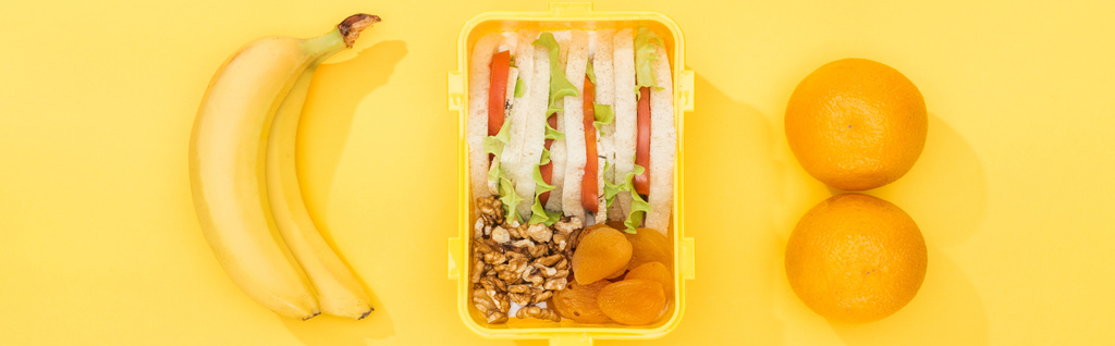 панорамный снимок коробки с едой рядом с бананами и апельсинами
 - Фото, изображение