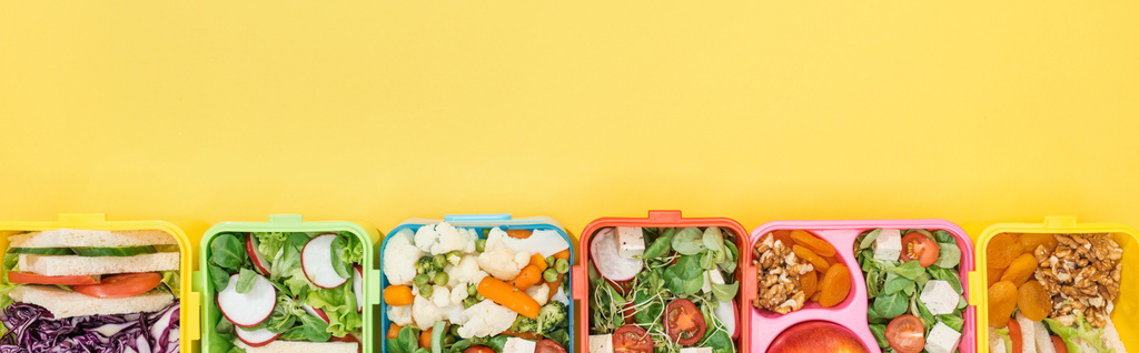 panoramic shot of lunch boxes with tasty food on yellow background - Photo, Image