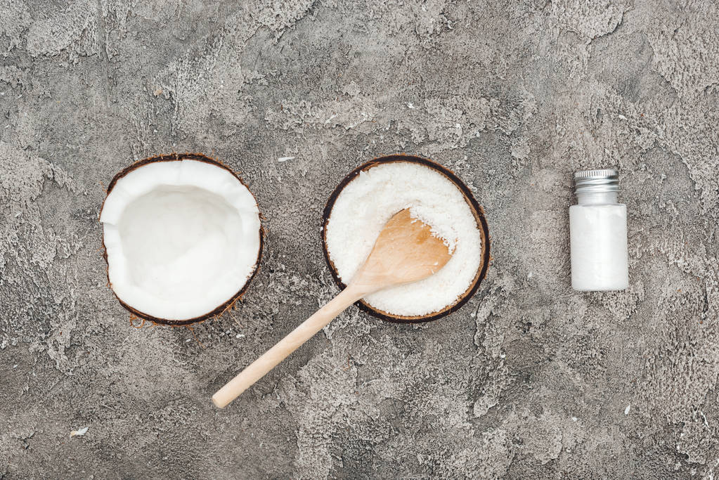 płaski lay z kokosów, drewniana łyżka i krem kokosowy na szarym tle teksturowane - Zdjęcie, obraz