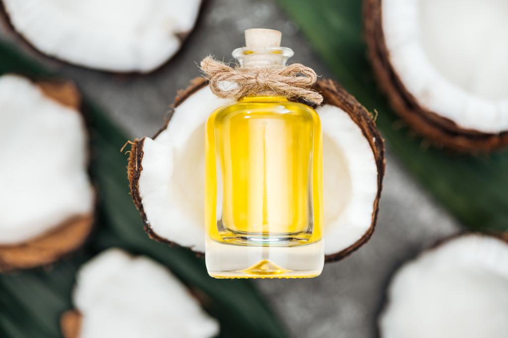 селективний фокус кокосової олії в пляшці на білій кокосовій половині
  - Фото, зображення