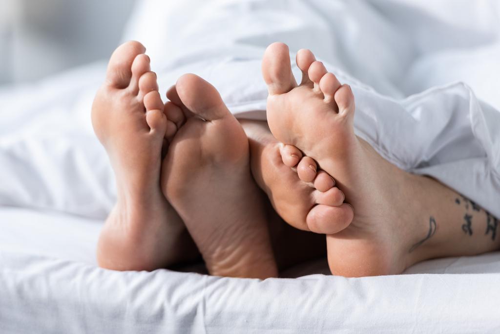 osittainen näkymä kaksi paljain jaloin lesbot makaa peiton alla
 - Valokuva, kuva