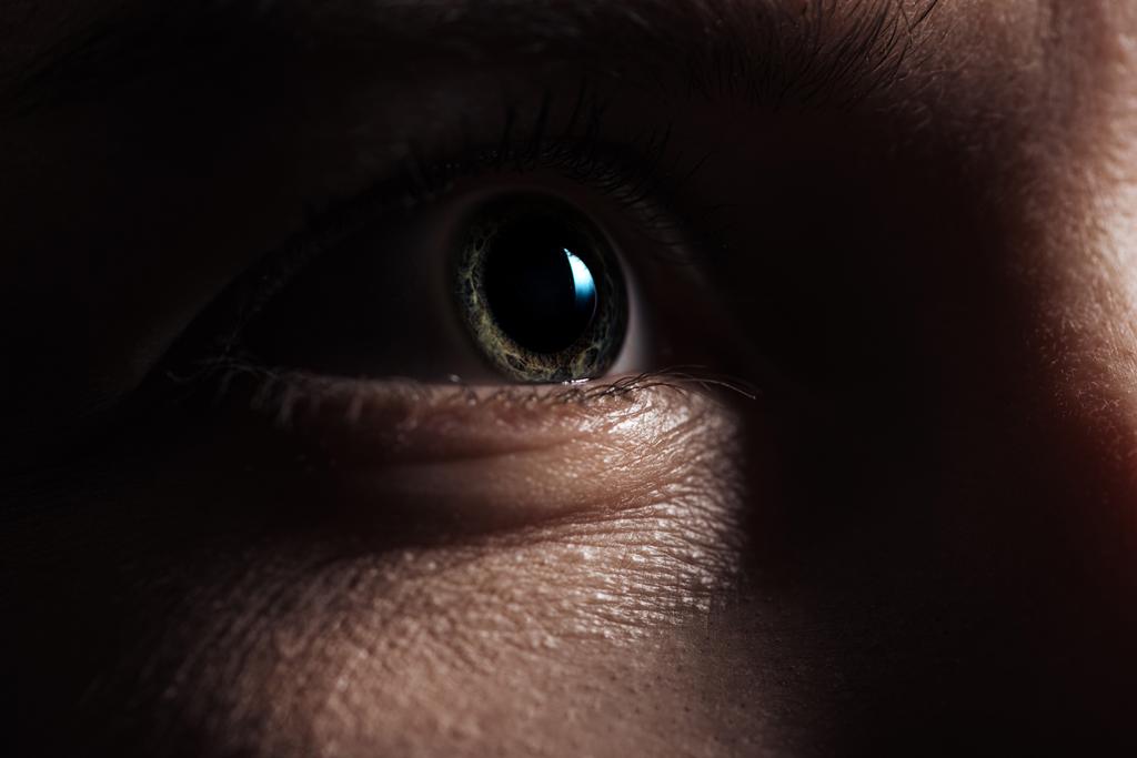 крупный план глаза взрослого мужчины, глядящего вдаль в темноте
 - Фото, изображение