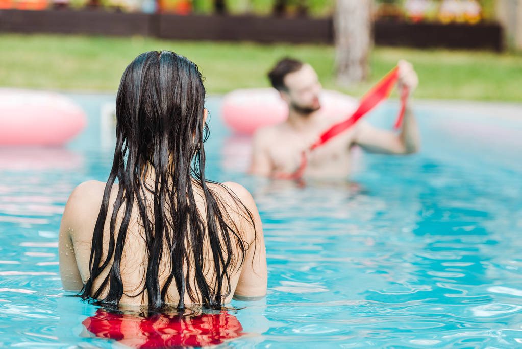 vista posteriore della donna che nuota in piscina vicino all'uomo
  - Foto, immagini