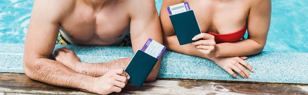 plano panorámico del hombre y la mujer sosteniendo pasaportes con billetes de avión
  - Foto, imagen