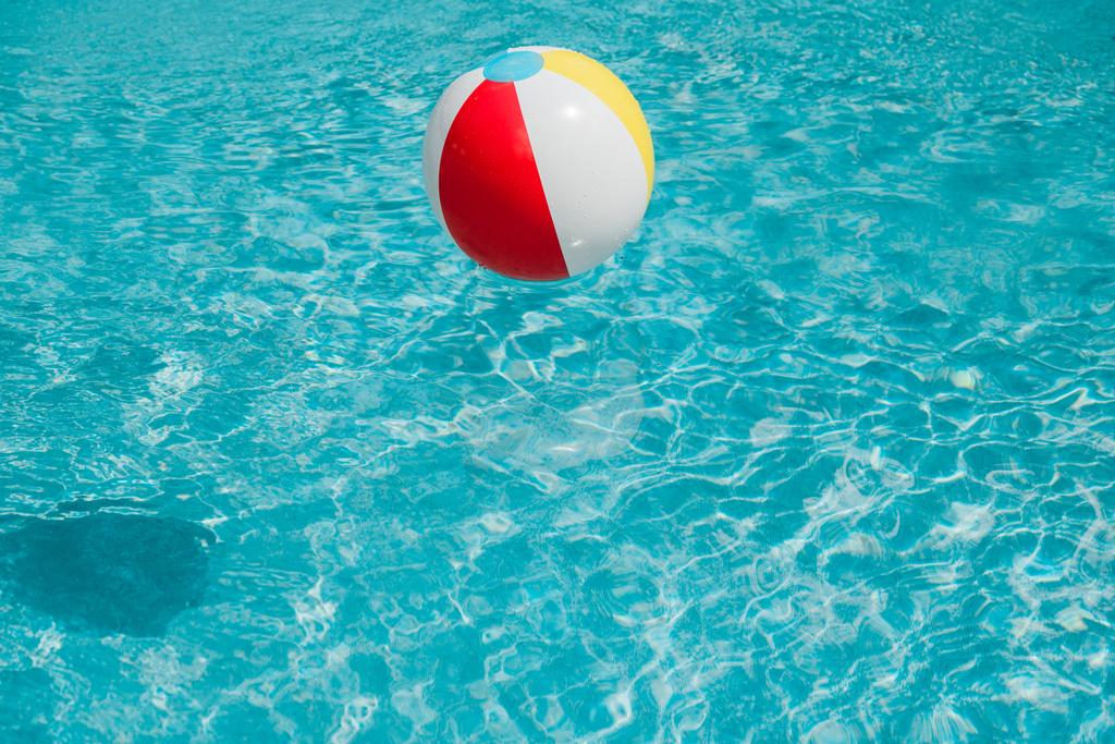 bola inflável colorida na água azul limpa na piscina
  - Foto, Imagem