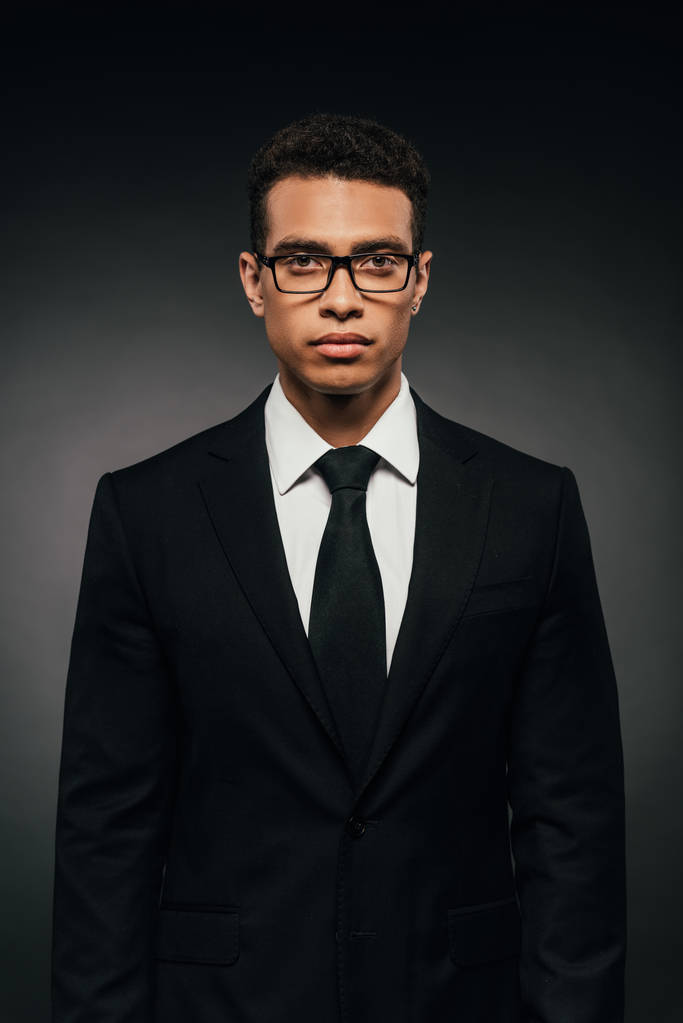african american businessman in glasses and suit on dark background - Photo, Image