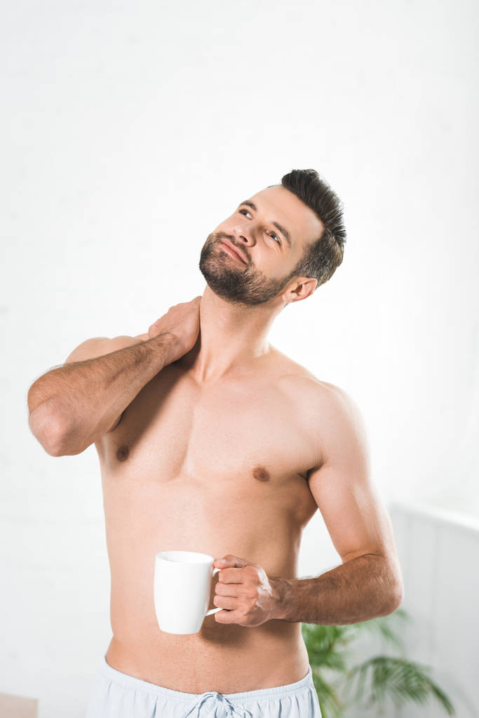 hombre guapo sin camisa sosteniendo la taza de café en casa por la mañana
 - Foto, Imagen