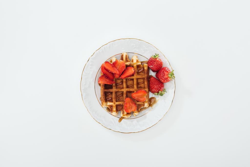 vue de dessus de la petite assiette avec des fraises sur gaufre sur blanc
 - Photo, image