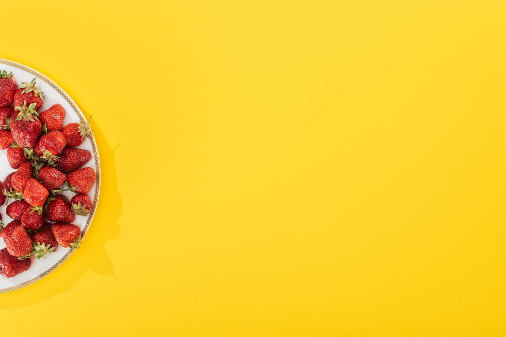 πάνω όψη της πλάκας με φράουλες σε κίτρινο - Φωτογραφία, εικόνα