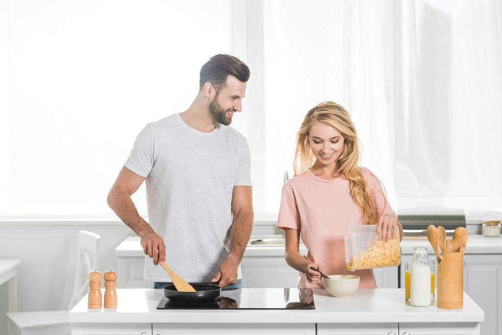 beautiful couple cooking breakfast together at kitchen - Photo, Image