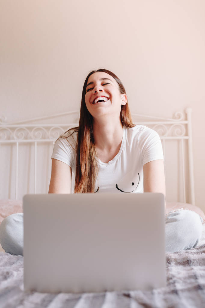 bella giovane donna ridere e scrivere sul suo computer portatile
 - Foto, immagini