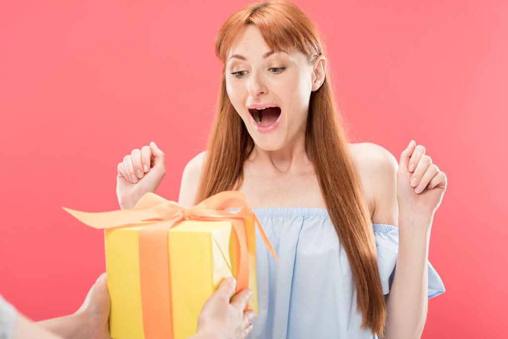 περικομμένη θέα του ανθρώπου δίνοντας κουτί δώρο με κορδέλα να ενθουσιασμένος κοκκινομάλλα κορίτσι γενεθλίων απομονωθεί σε ροζ - Φωτογραφία, εικόνα