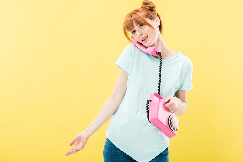 atractiva pelirroja joven hablando por teléfono retro aislado en amarillo
 - Foto, imagen
