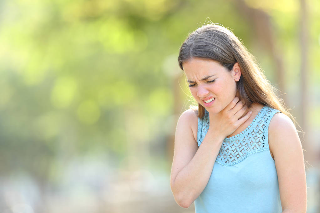 Mujer sufriendo dolor de garganta en un parque
 - Foto, imagen