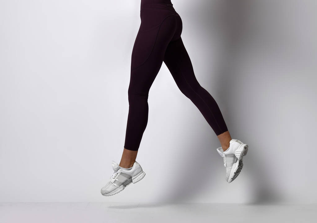 Sportieve vrouw benen wandelen in sport slijtage op een witte - Foto, afbeelding