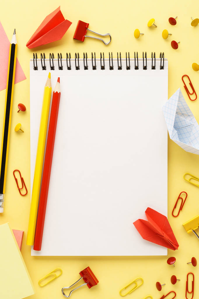 School notebook en diverse rode en gele briefpapier. - Foto, afbeelding