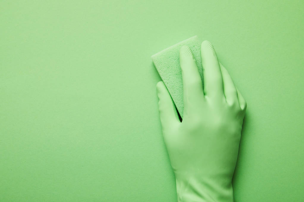 abgeschnittene Ansicht eines Mannes im Gummihandschuh mit grünem Schwamm  - Foto, Bild