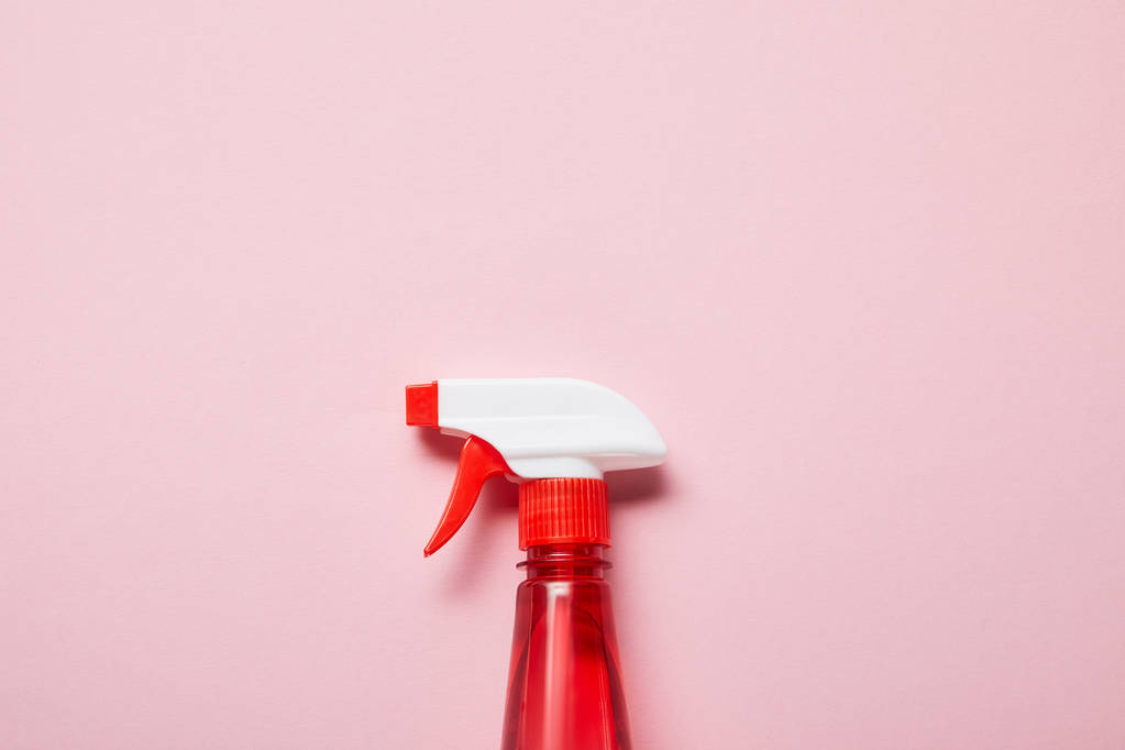 ピンクの背景にスプレーと赤いボトルのトップビュー  - 写真・画像