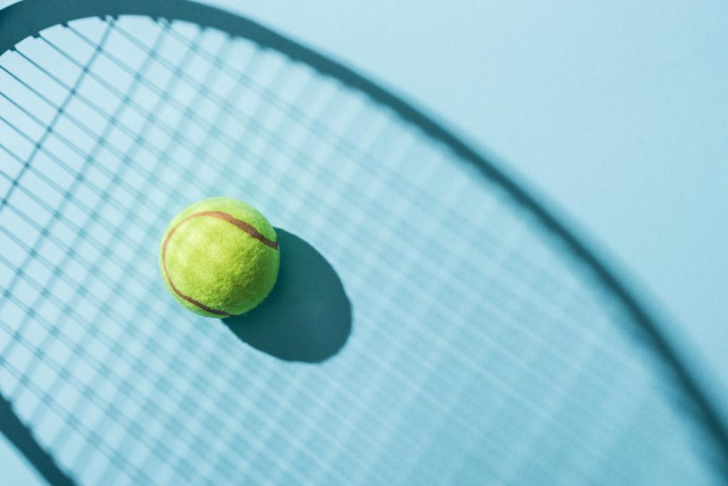 青のテニスラケットの影の近くのテニスボールのトップビュー  - 写真・画像