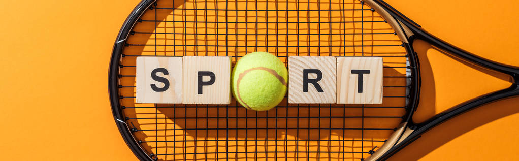 panoramiczny strzał z drewnianych kostek z napisem sportowym w pobliżu piłki tenisowych i rakieta tenisowa na żółtym  - Zdjęcie, obraz