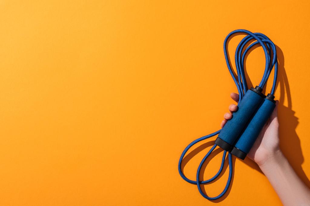 обрізаний вид жінки, що тримає синю мотузку на жовтому
  - Фото, зображення