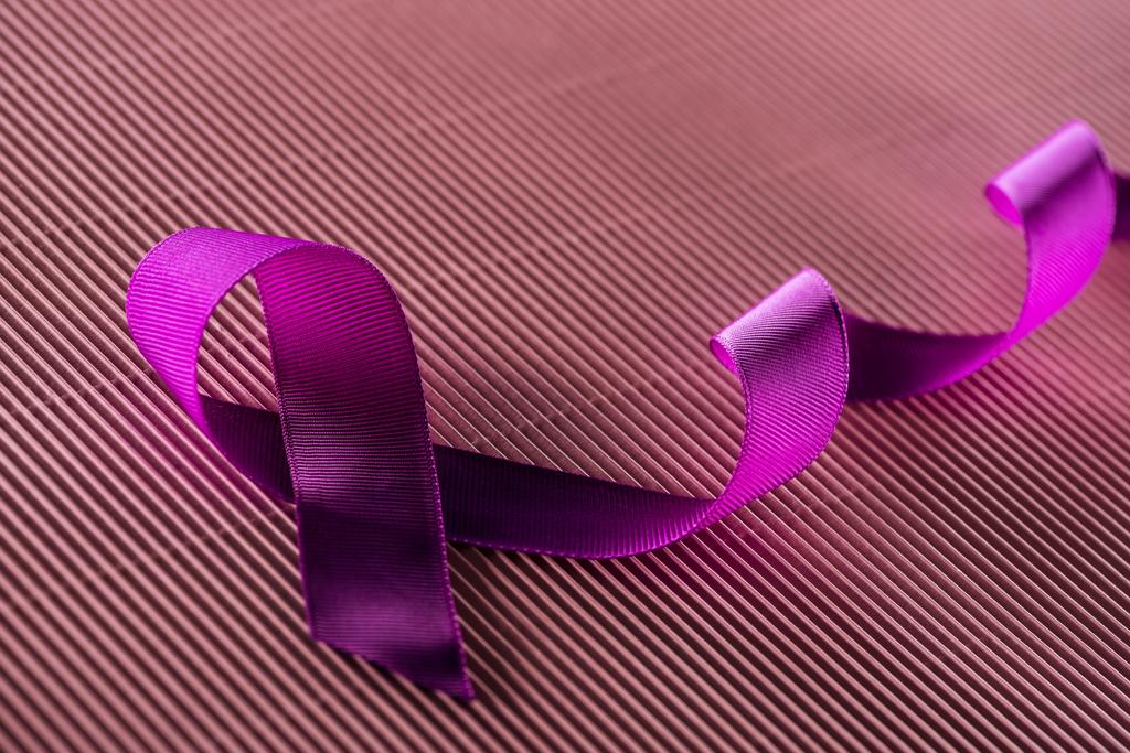 cinta púrpura sobre fondo de textura rosa en sombra
 - Foto, imagen