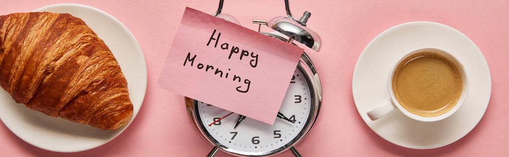 ピンクの背景、パノラマショットにコーヒーとクロワッサンの近くに付箋に幸せな朝の文字と目覚まし時計のトップビュー - 写真・画像