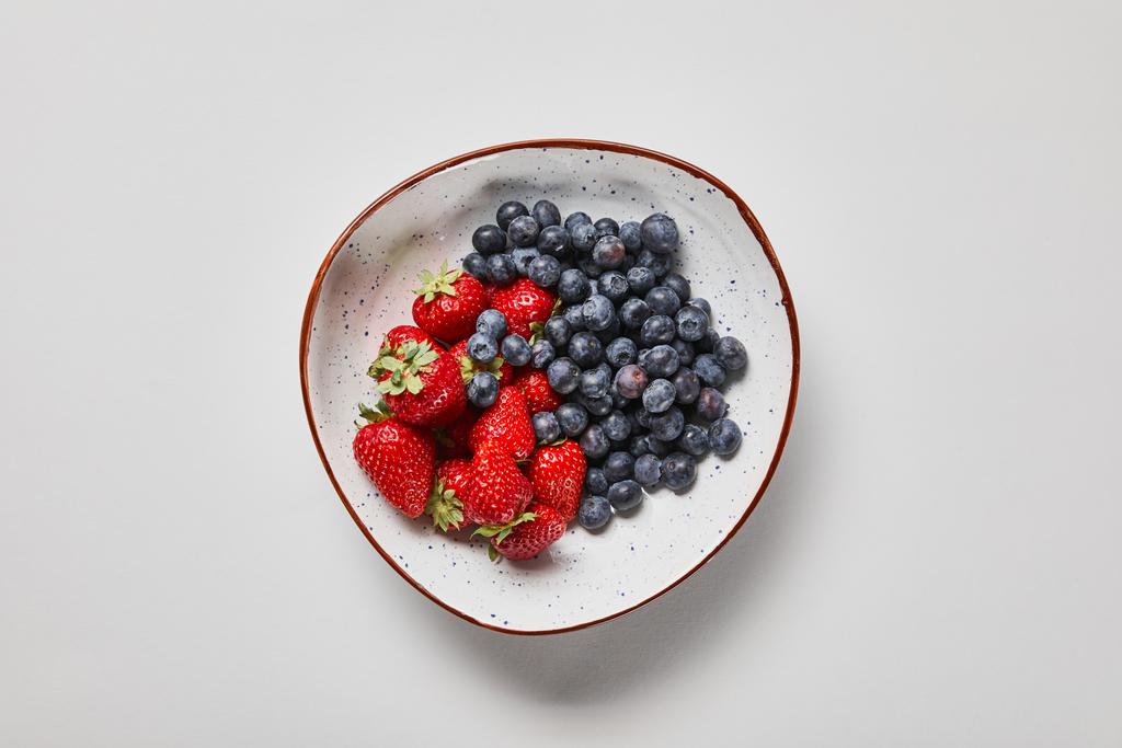 vista superior de plato grande con deliciosos arándanos y fresas
 - Foto, imagen