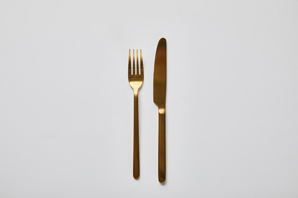 vista superior de garfo dourado e faca isolada em branco
 - Foto, Imagem