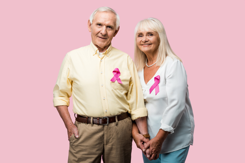 wesoły emerytowany para z szarymi włosami i wstążkami wyizolowanymi na różowym  - Zdjęcie, obraz
