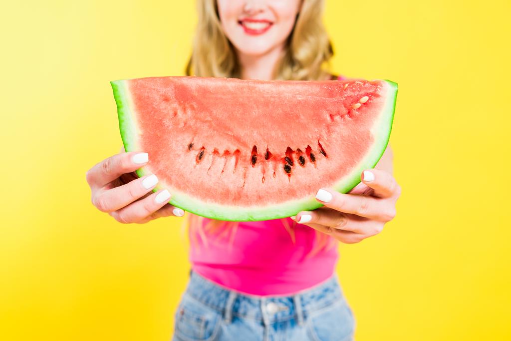 gedeeltelijke weergave van gelukkig meisje met watermeloen op geel - Foto, afbeelding