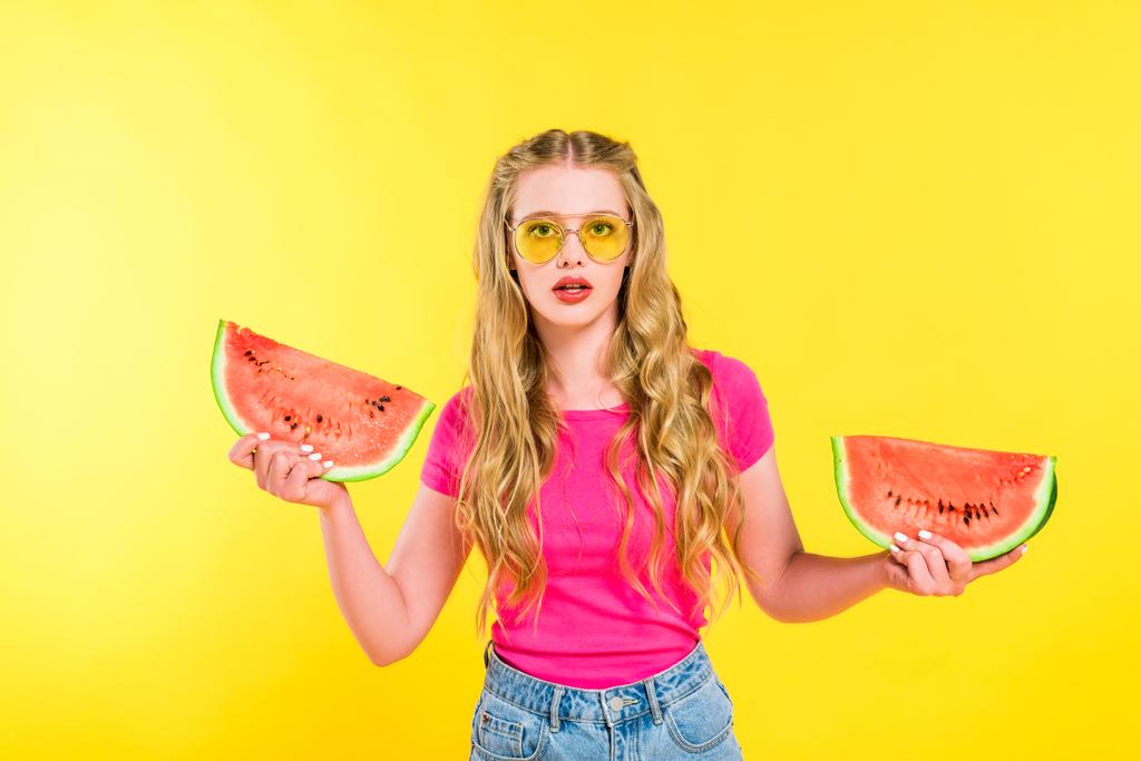 schöne verwirrte Mädchen in Sonnenbrille mit Wassermelone isoliert auf gelb - Foto, Bild