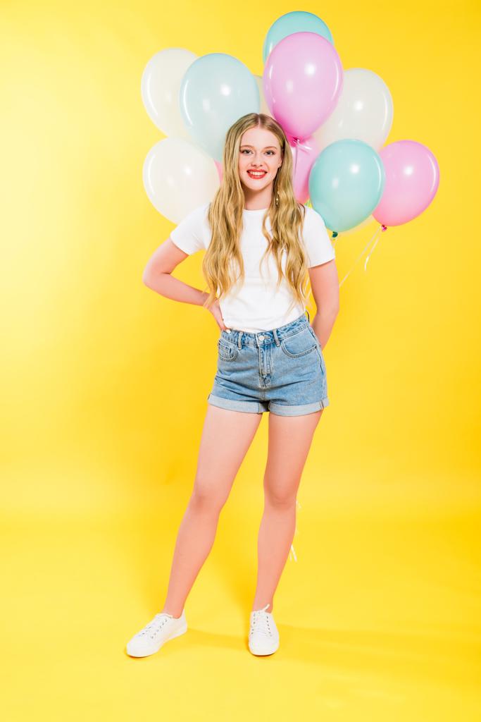 όμορφη χαμογελαστή κορίτσι με μπαλόνια στο κίτρινο - Φωτογραφία, εικόνα
