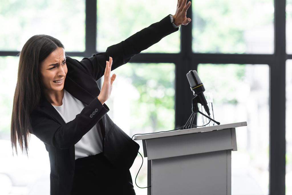 conférencier effrayé souffrant de la peur de parler en public geste avec les mains tout en se tenant sur le podium tribune dans la salle de conférence
 - Photo, image