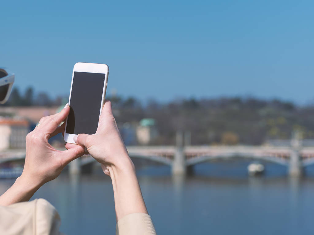 junge Frau benutzt Handy im Freien in europäischer Stadt - Foto, Bild