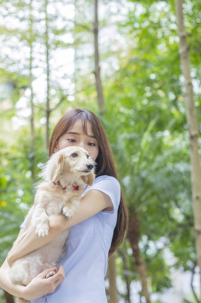 Fiatal ázsiai nő kutyával az utcán - Fotó, kép