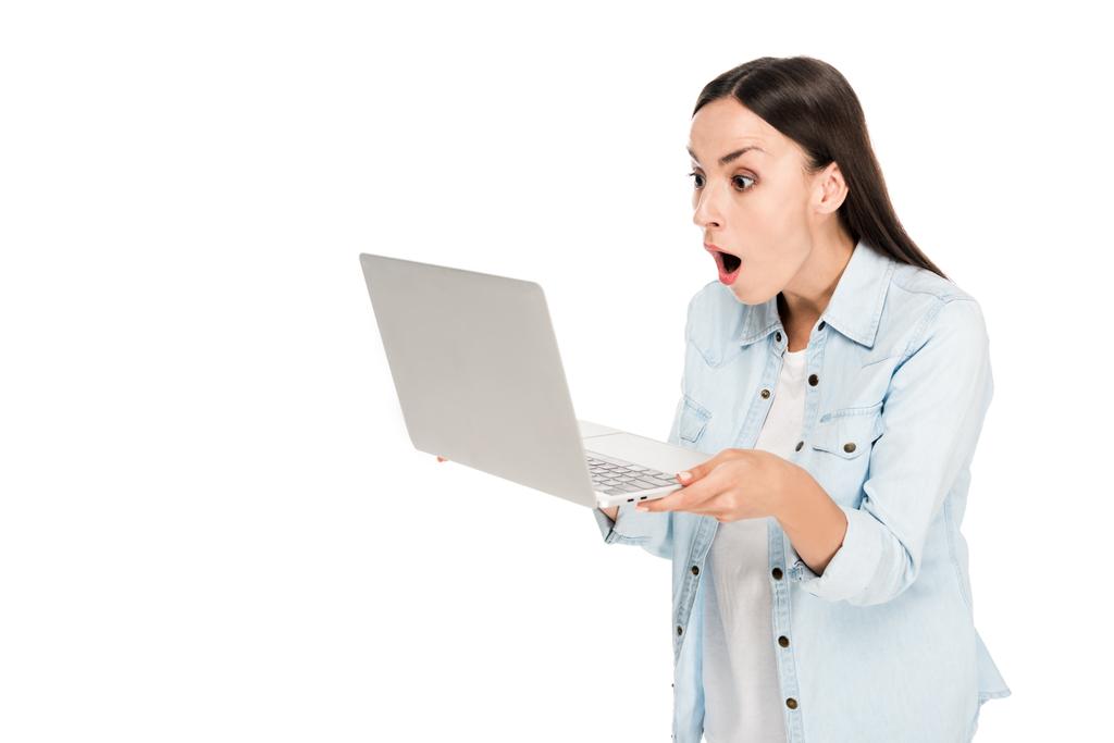 döbbent lány farmer kabát segítségével laptop elszigetelt fehér - Fotó, kép