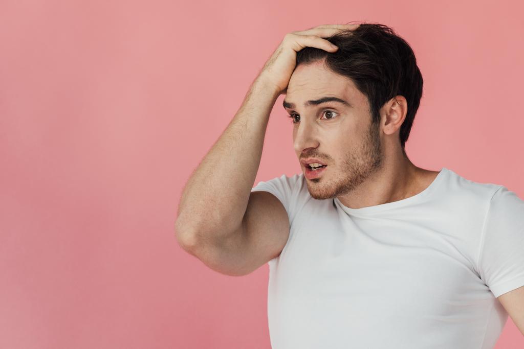 shocked muscular man in white t-shirt touching head isolated on pink - Photo, Image