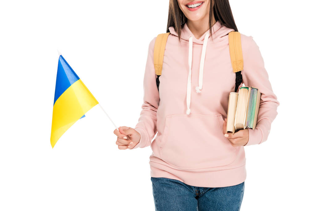 vista cortada de estudante sorrindo com mochila segurando bandeira ucraniana e livros isolados em branco
 - Foto, Imagem