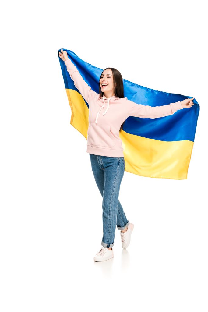 πλήρες μήκος θέα του ευτυχισμένο νεαρό κορίτσι κρατώντας σατέν σημαία της Ουκρανίας απομονωθεί σε λευκό - Φωτογραφία, εικόνα