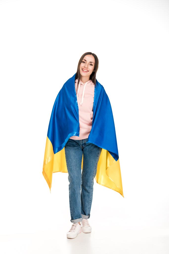 πλήρες μήκος θέα του ευτυχισμένο νεαρό κορίτσι σε σατέν σημαία της Ουκρανίας απομονωθεί σε λευκό - Φωτογραφία, εικόνα